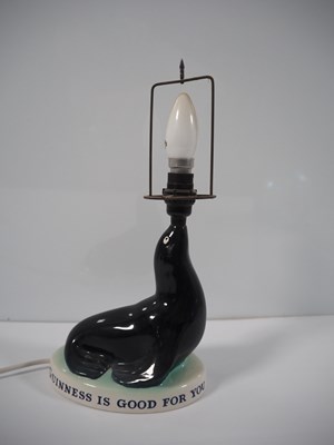 Lot 404 - GUINNESS: Carlton Ware Sealion Lamp with...