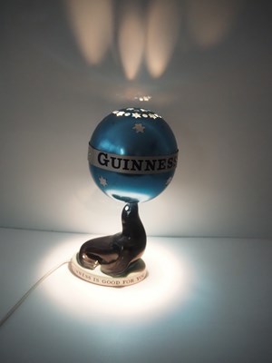 Lot 404 - GUINNESS: Carlton Ware Sealion Lamp with...