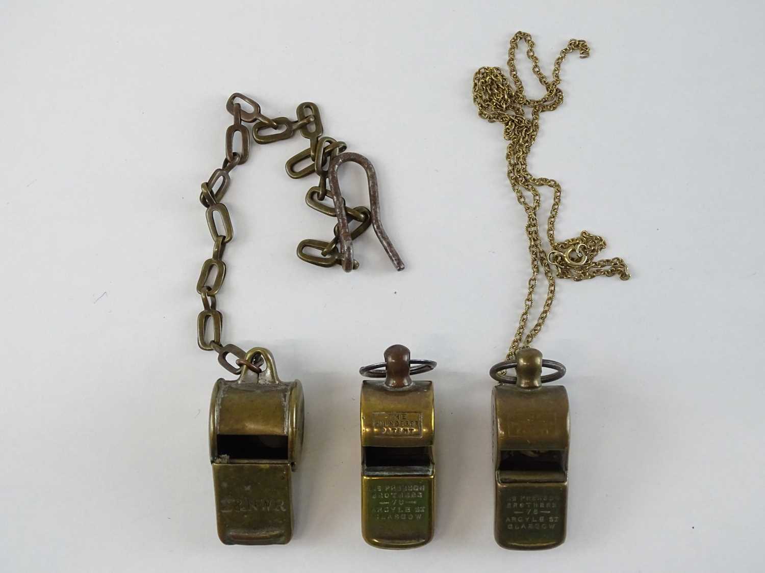 Lot 65 - A group of brass Thunderer Patent whistles all...